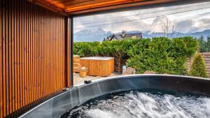 a hot tub in a house with a view of mountains at Villa Delta Boutique in Kościelisko