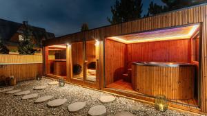 a wooden house with a large hot tub in it at Villa Delta Boutique in Kościelisko