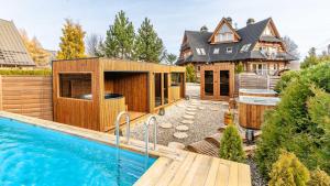 a home with a swimming pool and a house at Villa Delta Boutique in Kościelisko