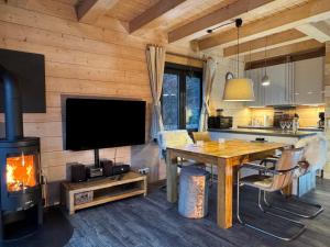 a kitchen and living room with a fireplace in a log cabin at Harz-Blockhaus, 4 und 5 Sterne, Sauna - und Kamin - KH in Hahnenklee-Bockswiese +13 photos