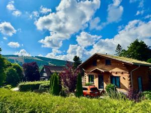 a house with a truck parked in front of it at Harz-Blockhaus, 4 und 5 Sterne, Sauna - und Kamin - KH in Hahnenklee-Bockswiese