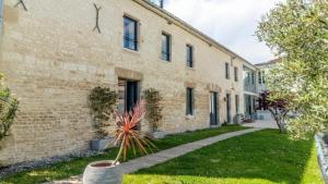 a brick building with a plant in a yard at Domaine Ericarclem in Aigrefeuille-dʼAunis