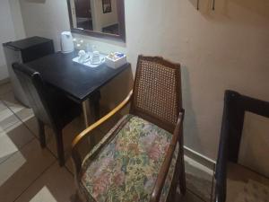 a table and a chair with a table and a table and a table at Swasti Guesthouse in Boksburg