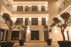 a building with trees in the middle of a courtyard at Exotik City Apartments 5 in Dos Hermanas