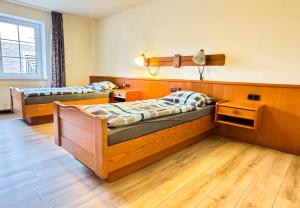 two beds in a room with wooden floors at Hotelkamer voor twee personen op de begane grond 33-6 in Bunkenburg