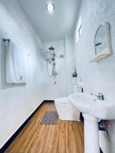 Un baño blanco con lavabo e inodoro. en Panda Guest House, en Corón