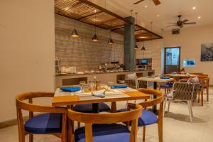 a dining room with wooden tables and chairs at Sky Beach Maldives - Dhiffushi in Dhiffushi