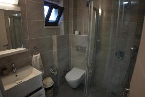 a bathroom with a shower and a toilet and a sink at HK Resort  +36 photos