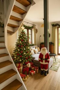a santa claus standing in front of a christmas tree at Bórówka in Ujsoły