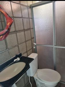 een kleine badkamer met toilet en wastafel bij Casabeiramaritamaracá in Itamaracá