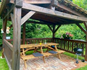 a wooden pavilion with a picnic table and a grill at Chalupa Laura in Bublava