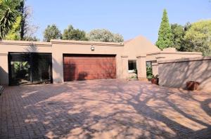 a house with a brick driveway in front of a garage at The Condor Nest! in Sandton