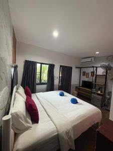 a bedroom with a large white bed with red pillows at Krabi Nemo House in Ao Nang Beach