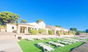 eine Gruppe weißer Gartenstühle vor einem Gebäude in der Unterkunft Gaspro3 - Maison une chambre climatisée proche de St Tropez in Gassin