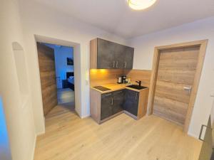 蒂罗尔州霍尔Stylish 1-Bedroom Old Town Retreat的铺有木地板的厨房,配有木制橱柜。