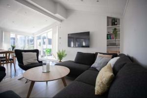 ein Wohnzimmer mit Sofa und Tisch in der Unterkunft 3BR Modern Penthouse Apartment in the Heart of Torshavn in Tórshavn