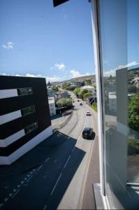 Ein Auto fährt eine Straße entlang von einem Gebäude in der Unterkunft 3BR Modern Penthouse Apartment in the Heart of Torshavn in Tórshavn + 16 Fotos