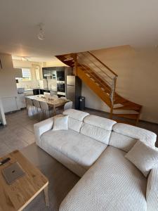 un soggiorno con un divano bianco e un tavolo di Maison vue sur le lac et proche du golf ! a Bourges