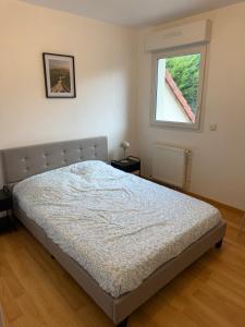 un letto in una camera da letto con finestra di Maison vue sur le lac et proche du golf ! a Bourges