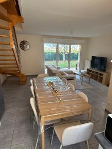 un soggiorno con tavolo e sedie in legno di Maison vue sur le lac et proche du golf ! a Bourges