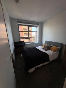 um quarto com uma cama grande e uma janela em Cozy and Spacious Central London Stay in Canary Wharf with a City View & a Private Bathroom for Luxury Comfort at a Great Value em Londres