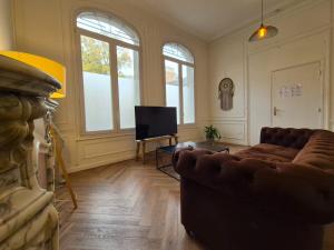 ein Wohnzimmer mit Couch und Flachbildfernseher in der Unterkunft Bogota - Charme central à Reims - 6P in Reims