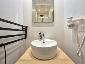 ein Badezimmer mit einem weißen Waschbecken und einem Spiegel in der Unterkunft Bogota - Charme central à Reims - 6P in Reims