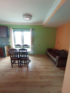 una sala de estar con una mesa, sillas y un sofá en Maskey Niwas, en Katmandú