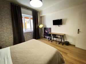 a bedroom with a bed and a desk and a television at Maison Voyage Messina in Messina +81 photos