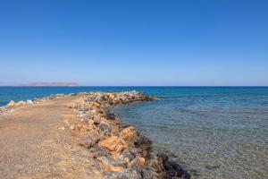 Niros Beachfront Aparthotel في كوكيني خانيون: مجموعة كبيرة من الصخور على شاطئ المحيط