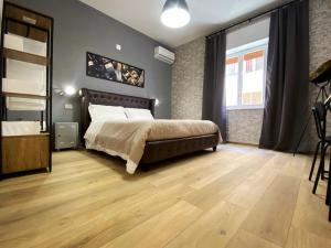 a bedroom with a large bed and a wooden floor at Maison Voyage Messina in Messina