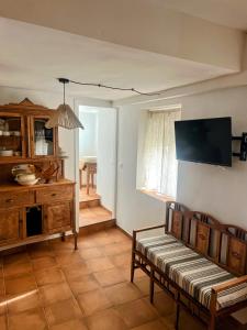 阿尔卡拉德尔胡卡尔Casa cueva del sastre Alcalá del Júcar的客厅里有一张沙发和一台电视 更多23张照片