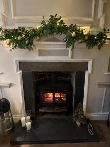 Una sala de estar con chimenea con un árbol de Navidad. en Maes Y Neuadd Country House, en Talsarnau