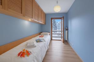 Bett in einem Zimmer mit blauen Wänden in der Unterkunft Appartamento Alpine Suite - Happy Rentals in Sestriere