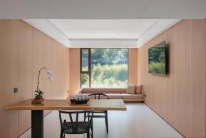 ein Esszimmer mit Tisch und Stühlen und einer Couch in der Unterkunft Shuitiao Boli Hotel (Yangshuo Shili Gallery Yulonghe Branch) in Gaotian