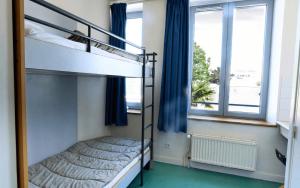 a bedroom with two bunk beds and a window at Auberge de Jeunesse HI Cherbourg in Cherbourg en Cotentin