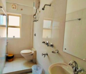 Un baño con inodoro, lavabo y ducha. en Iris Boutique Hotel, en Jaigaon