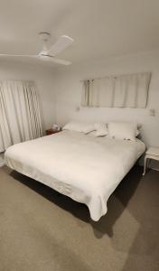 Un dormitorio con una gran cama blanca con techo. en The Weekend, en Papamoa