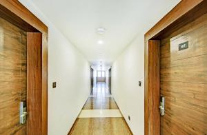 um corredor de um edifício com portas de madeira em FabHotel Pride Image - Rajarajeshwari Nagar em Bangalore