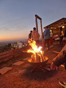 a fire pit with people standing around it at Old Chalet in Iaşi