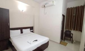 um quarto com uma cama e uma cadeira em FabHotel Pride Image - Rajarajeshwari Nagar em Bangalore