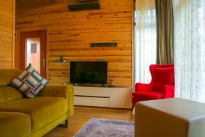 a living room with a couch and two red chairs at HK Resort 