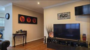 ein Wohnzimmer mit einem Flachbildfernseher an der Wand in der Unterkunft Kelso lifestyle in Kelso