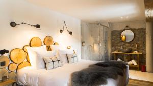 une chambre avec un grand lit blanc avec des bûches dessus dans l'établissement Grand Hôtel L'ermitage, à Font-Romeu