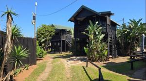 ein schwarzes Haus mit einem Zaun und einigen Palmen in der Unterkunft Kelso lifestyle in Kelso