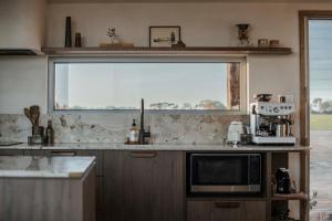 a kitchen with a large window and a microwave at Box Hill Esperance in Esperance