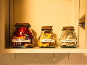 Drei Einmachgläser mit Lebensmitteln stehen im Regal. in der Unterkunft ALP BREAK 2 - Nel Borgo Storico del Ponte Romano in Aosta + 11 Fotos