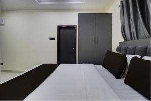 ein Schlafzimmer mit einem Bett und einem schwarzen Schrank in der Unterkunft Super Hotel O EMBASSYINN in Kondapur + 23 Fotos