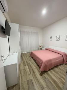 Un dormitorio con una cama con una manta rosa. en Domo Acabara, en Alghero
