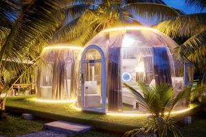a dome house with a lighted room in front of a palm tree at The Coco Journey - Eco Dome in Melaka